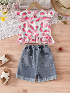 Girls summer outfit with watermelon print top and denim shorts on wooden background