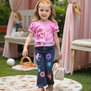 Détail du t-shirt rose à volants et du pantalon évasé en jean brodé de fleurs