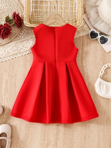 Flat lay of red sleeveless girl's dress with pleated skirt and elegant floral accessories