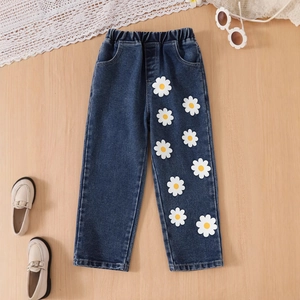 Détail d'un jean bleu pour fille avec imprimés pâquerettes et taille élastiquée