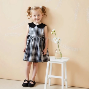Détail d'une robe vichy noire et blanche pour filles avec col Claudine et sans manches