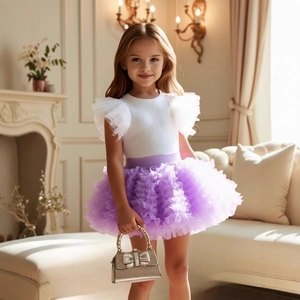 Close-up of girls white knit top with ruffled mesh sleeves and purple tulle skirt