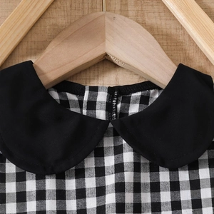 Détail du col Claudine noir sur une robe d'été vintage à carreaux pour fille