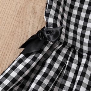 Détail du nœud en satin noir sur la robe vichy vintage noire et blanche pour filles