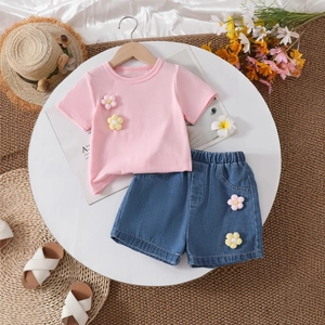Detail of pink cotton T-shirt and denim shorts with handcrafted 3D floral decorations