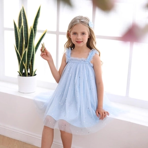 Détail de robe en tulle bleu clair avec imprimés lune étoile et bretelles à volants