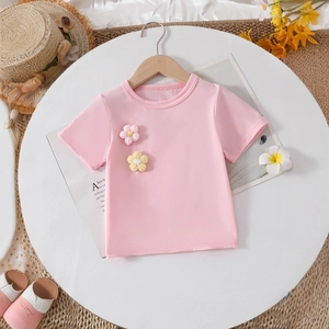 Close-up of pink cotton T-shirt featuring decorative 3D knitted flowers for girls