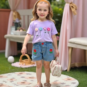 Detail view of girls purple cotton T-shirt with 3D floral appliques and denim shorts
