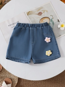 Detail of blue denim shorts for girls featuring elastic waist and knit flower embroidery