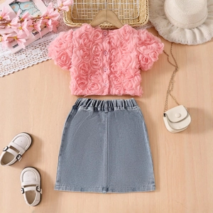 Détail à plat d'un ensemble chemise rose à fleurs 3D et jupe en jean bleue pour filles
