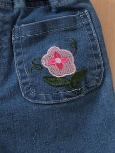 Girls denim shorts with floral embroidery and pink petals on dark blue washed fabric