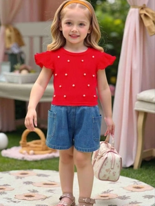 Girl's red knit top with ruffled sleeves and pearl accents paired with denim shorts