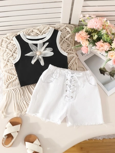Girls summer two-piece outfit with black floral tank top and white lace-up denim shorts