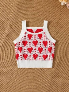 Mädchen Strickweste mit Herzmuster in Rot und Weiß auf Boho-Matte für den Sommer