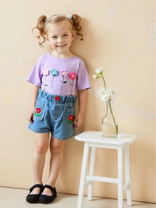 Girls summer casual set with lavender floral t-shirt and denim shorts shown on model