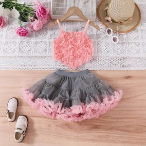 Flat lay view of pink floral top and grey tulle tutu skirt set with cute accessories