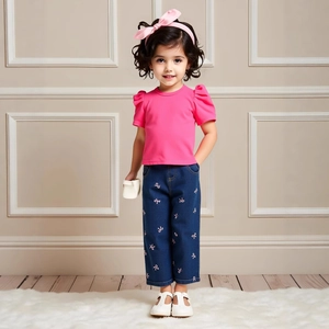 Detail of girls' pink puff sleeve top and blue denim pants with bow embroidery