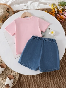 Girl's summer outfit with pink t-shirt and denim shorts on a sunny vacation background