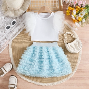 Detailed view of girls' white ribbed top with mesh trim and blue layered tutu skirt