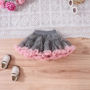 Detailed flat lay of pink floral tutu dress with grey mesh and elegant accessories