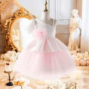Détail du haut blanc à une épaule et jupe en tulle rose avec grande fleur 3D pour fille