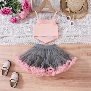 Flat lay of pink cropped tank top and layered grey tulle tutu skirt for girl's outfit