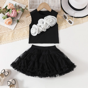Flat lay of girl's summer two-piece set with 3D floral top and black layered tutu skirt