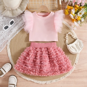 Flat lay of pink girls' ruffled knit top and tiered tutu mesh skirt for birthday outfit