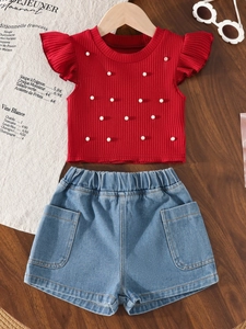 Detail of red ruffle-sleeve top with white pearls and blue denim shorts set for girls