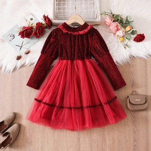 Dettaglio dell'abito da bambina in velluto con colletto a balze e gonna in tulle rosso