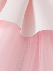 Détail du tissu blanc et du tulle rose plissé sur une robe de princesse pour fille