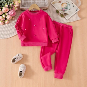 Flat lay of pink girls' tracksuit with pearl beads, ruffled sleeves and matching joggers