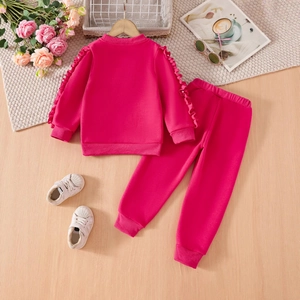 Detail of girls' rose red sweatshirt with ruffles and pearl beads on sleeves