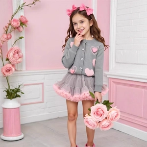 Détail de gilet gris à cœurs et jupe en tulle rose pour fille avec accessoire de cheveux