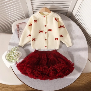 Détail du cardigan crème à nœuds rouges et de la jupe tutu bordeaux pour fille