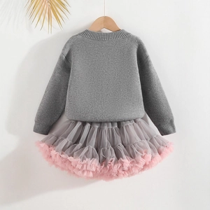 Détail du pull en maille gris et de la jupe tutu grise avec volants en tulle rose