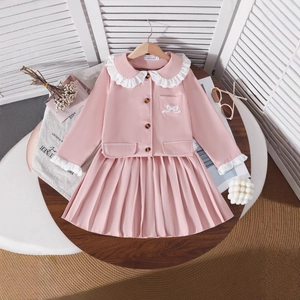 Detail of pink girls outfit with Peter Pan collar lace shirt and pleated skirt set