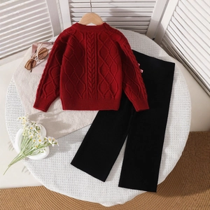 Detailed flat lay of a red cable-knit sweater and black ribbed wide-leg pants for girls