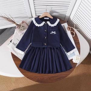 Close-up of girl's navy blue academy style dress with lace collar and bow embroidery