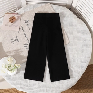 Detailed view of black ribbed knit wide-leg pants with elastic high waist and vertical texture