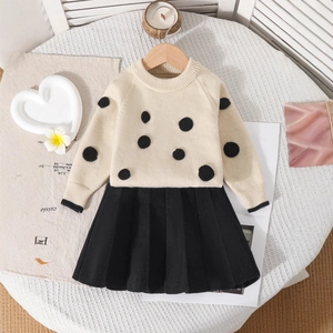 Détail du pull en maille douce à pois noirs et jupe plissée pour petite fille