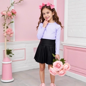 Close-up of girl's ribbed purple long-sleeve top and black pleated skirt with subtle sequins