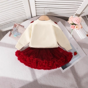 Vue détaillée d'un ensemble pull en tricot beige et jupe tutu rouge pour petite fille