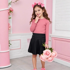 Detail showing pink ribbed long-sleeve top paired with a black pleated skirt for girls