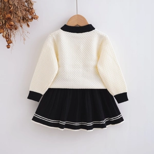 Detailed view of kids' white knit top with 3D honeycomb texture and black pleated skirt
