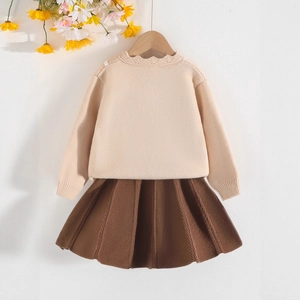 Dettaglio del cardigan in maglia per bambine con colletto in pizzo e gonna a pieghe