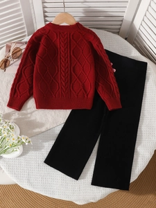 Girls red cable knit sweater set with black ribbed pants on a cozy white background