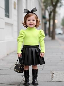 Ensemble fille avec pull en maille vert fluo et jupe plissée noire en similicuir