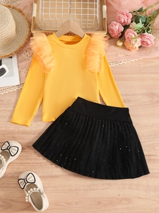 Girl's autumn outfit set with mustard knit top and sparkly black pleated skirt