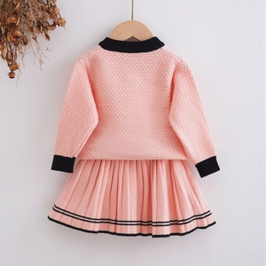 Close-up of pink knit set featuring 3D rose texture and contrasting black trim accents